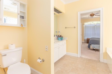 Full bathroom featuring vanity, ceiling fan, crown molding, and connected bathroom
