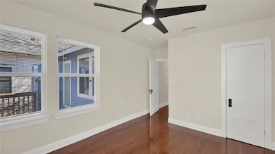 Unfurnished room with dark wood-type flooring and a ceiling fan