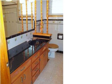 Hall bath with black cultured marble vanity top.