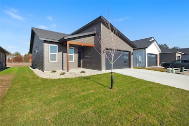 View of front of property featuring concrete driveway and a front lawn