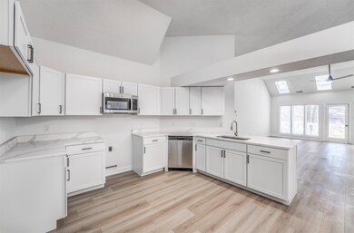 Kitchen featuring white cabinetry, sink, and appli