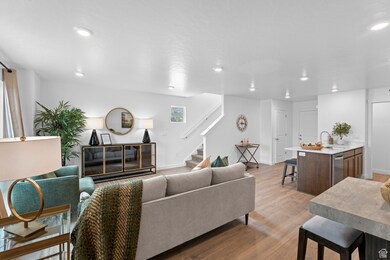 Living room with light wood finished floors, stairway, and recessed lighting