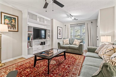 Living room featuring a ceiling fan, built in feat