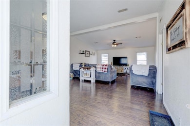 Living room featuring ceiling fan, dark hardwood /