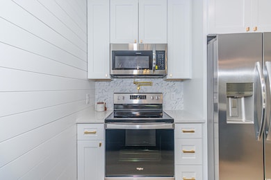Kitchen with white cabinets, stainless steel appli