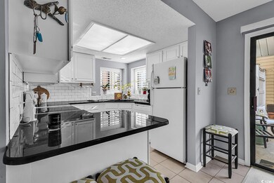 Kitchen with white cabinets, white fridge, kitchen