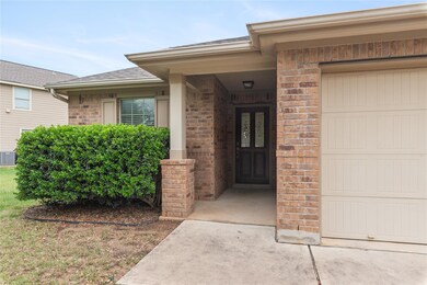 Entrance to property featuring brick siding, a ga