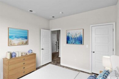Bedroom with baseboards, visible vents, and wood f