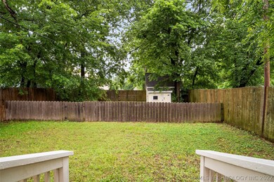 Back yard with two layers of fence and a shed.