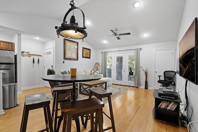 Dining room with vaulted ceiling, a ceiling fan, 