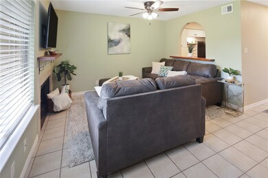 Living area with ceiling fan, light tile patterned
