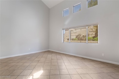 Empty room featuring high vaulted ceiling, light t