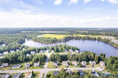 Aerial overview of property's location featuring a nearby body of water and nearby suburban area
