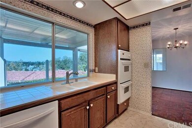 Another view of kitchen. Cooktop & hood, refrigera