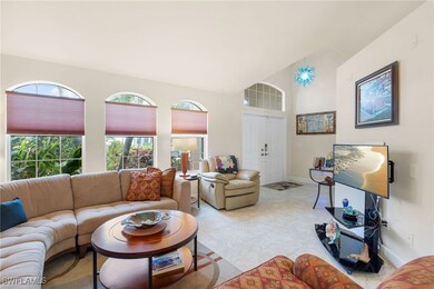 Living room with vaulted ceiling and light tile pa