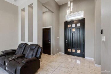 Entrance foyer featuring a high decorative ceiling, chandelier, tiled marble look finish floor, and
