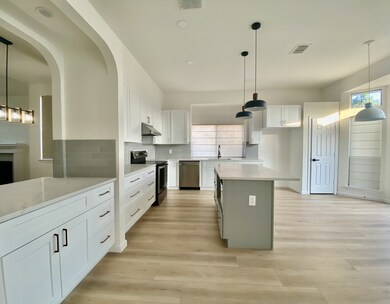 Kitchen featuring pendant lighting, white cabinetry, appliances with stainless steel finishes, backsplash, and recessed lighting