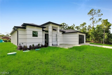 View of front facade featuring a front lawn, driveway, and an attached garage