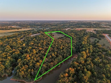 Aerial view at dusk of property boundaries highlighted and a wooded view