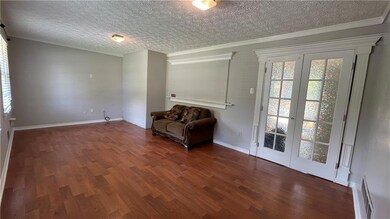 Unfurnished room with wood finished floors, a textured ceiling, and ornamental molding