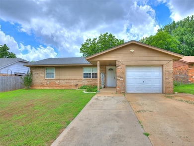 Single story home with brick siding, driveway, and a garage