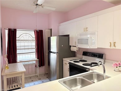 Kitchen with white microwave, electric range oven,