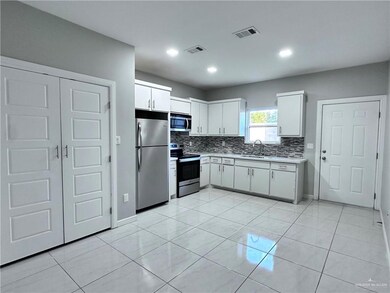 Kitchen with white cabinets, backsplash, light countertops, visible vents, and appliances with stainless steel finishes