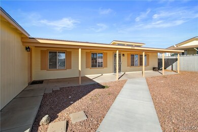 View of exterior entry with a patio area and fence