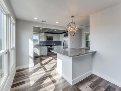 Kitchen with stainless steel appliances, wood fin