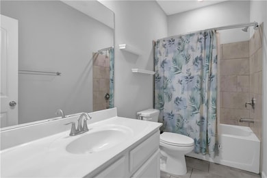 Full bath with vanity, toilet, shower / tub combo with curtain, and tile patterned floors
