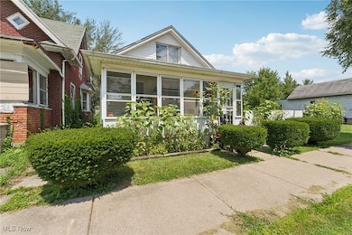 Bungalow featuring a sunroom and brick siding