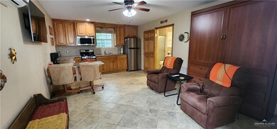 Kitchen featuring sink, stainless steel appliances, ceiling fan, backsplash, and light tile floors
