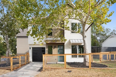 View of front of home with a fenced front yard, a gate, and an attached garage