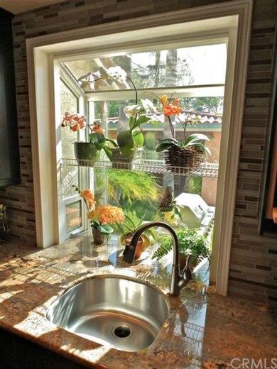 Garden window over the sink with a view of the yar