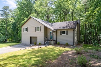 Split level home with a chimney, asphalt driveway,