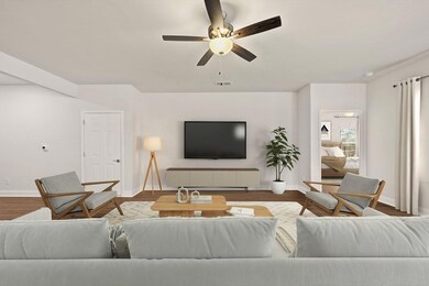 Living area featuring a ceiling fan, baseboards, and wood finished floors