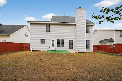 Rear view of property featuring a fenced backyard, a chimney, and roof with shingles