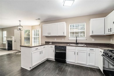 Kitchen featuring black appliances, dark hardwood 
