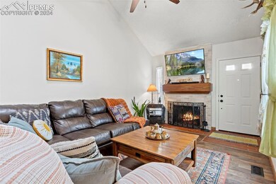 Living room with ceiling fan, a fireplace, hardwoo