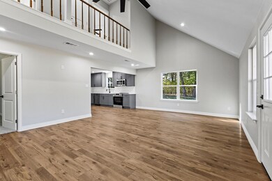 Unfurnished living room with high vaulted ceiling, dark wood-style flooring, plenty of natural light, recessed lighting, and ceiling fan