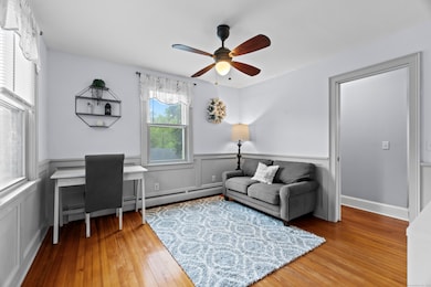 Charming bonus room offering endless flexibility: use as a den, home office, playroom, or creative nook-framed by classic trim, hardwood floors, and abundant natural light.