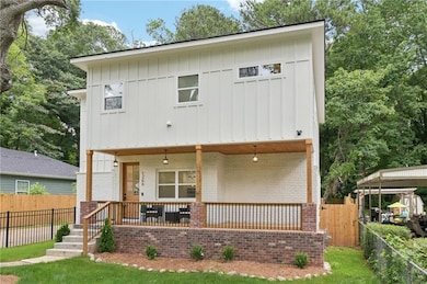 Back of house with brick siding, covered porch, and board and batten siding