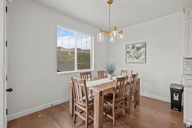 Dining space featuring light wood-type flooring and a chandelier