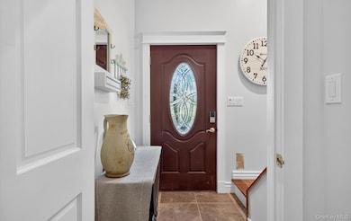 Entryway featuring dark tile patterned flooring and baseboards
