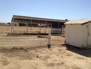 Pipe fenced horse corral, shade, and utility build