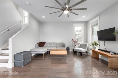 High end features fill the living area with pickled wood floors, window treatments and modern ceiling fan.