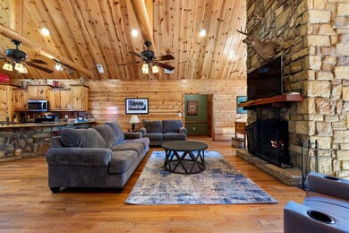 Living room with a fireplace, wooden walls, light 