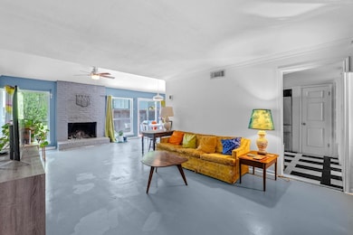 Living area featuring concrete floors, ceiling fa