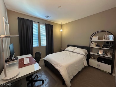 Bedroom featuring dark colored carpet and an offic