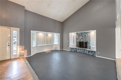Living room featuring baseboards, high vaulted cei